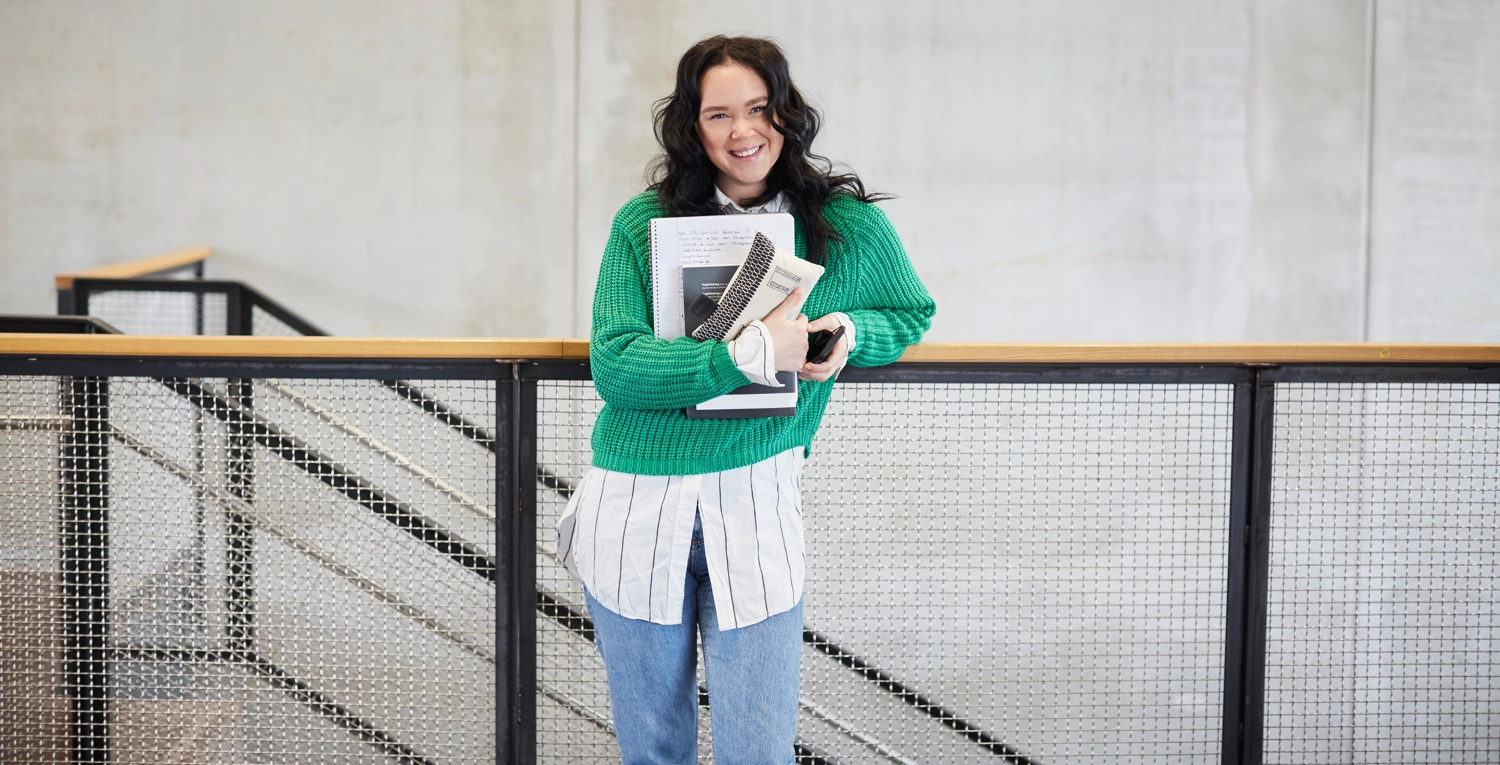 Glad ung tjej vid trappräcke ingångslön.webp