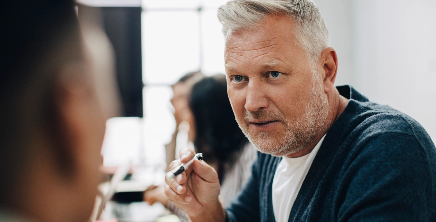 En man i närbild med en penna i handen, framtid arbetsliv samhällsvetare