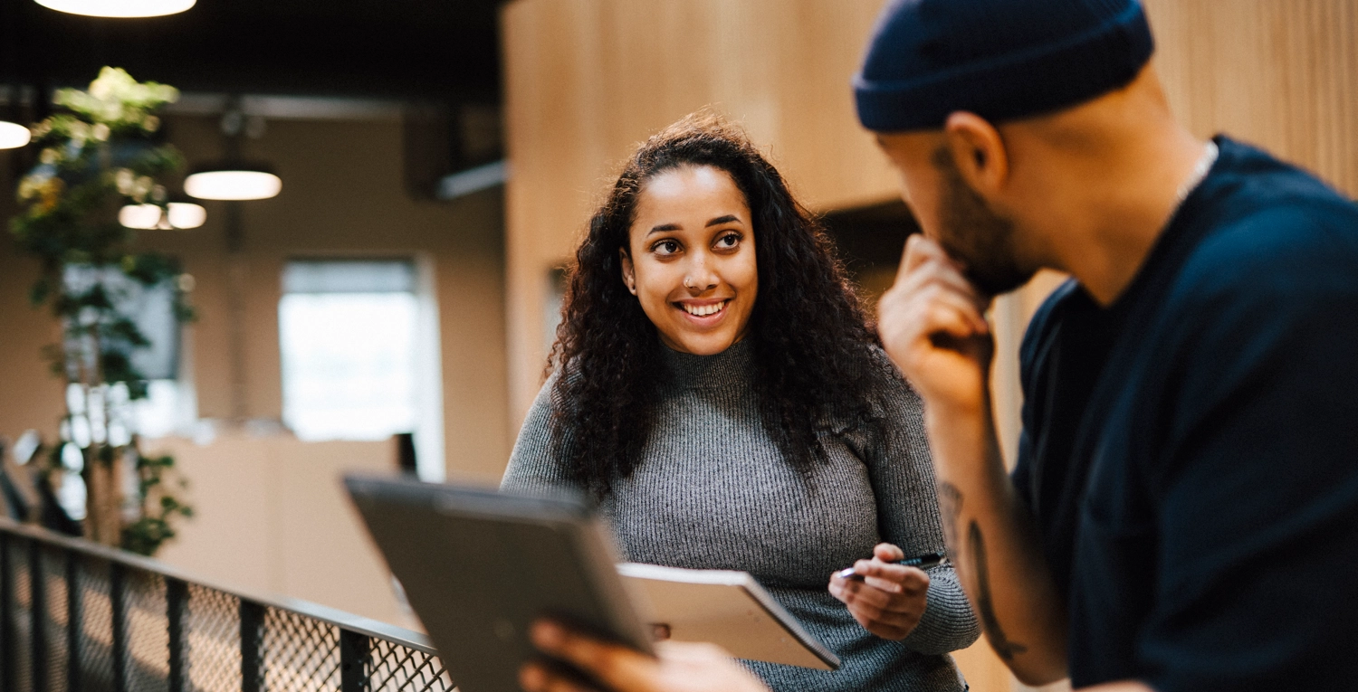 Student med mörkt hår i samtal med arbetsgivare på arbetsmarknadsmässa