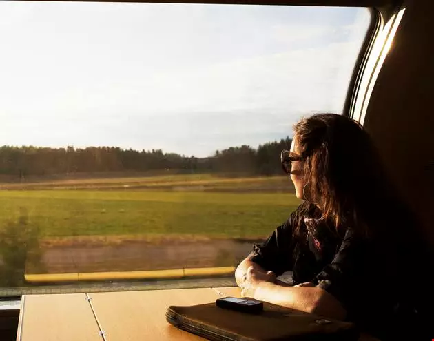 Kvinna som reser med tåg på sommaren