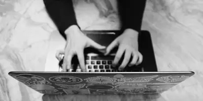Händer-skriver-på-laptop,-klistermarke